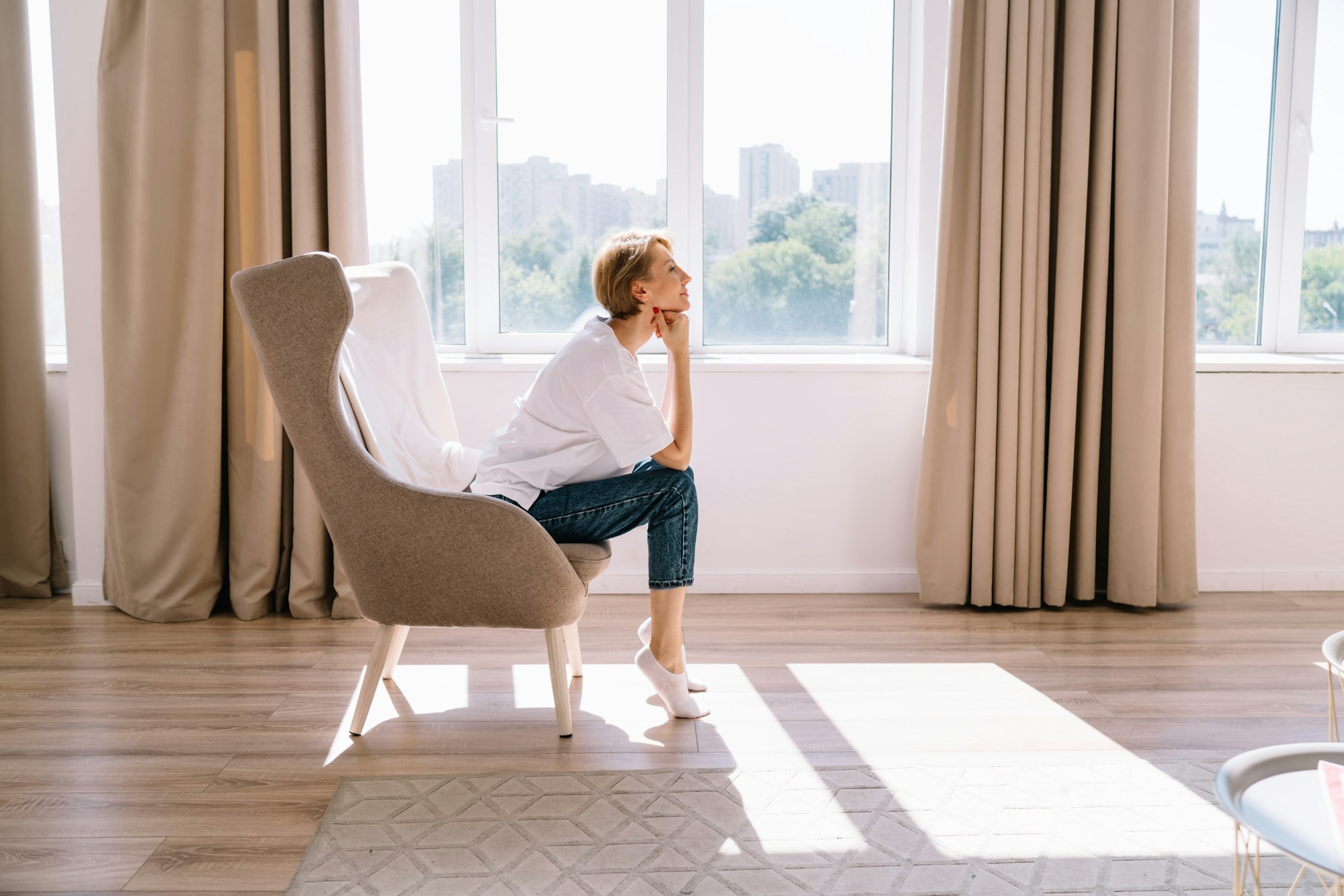 Relaxed woman sitting in armchair near window